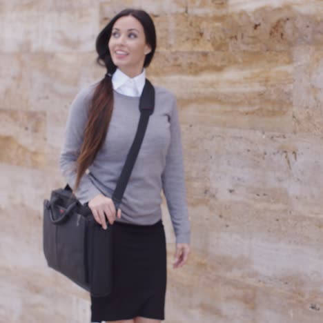 Gorgeous-business-woman-walking-past-wall