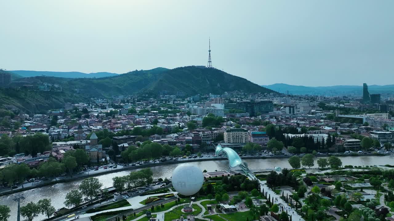 Eski Tiflis'in Barış Köprüsü ve teleferiği ile güneşli havada drone çekimi.
