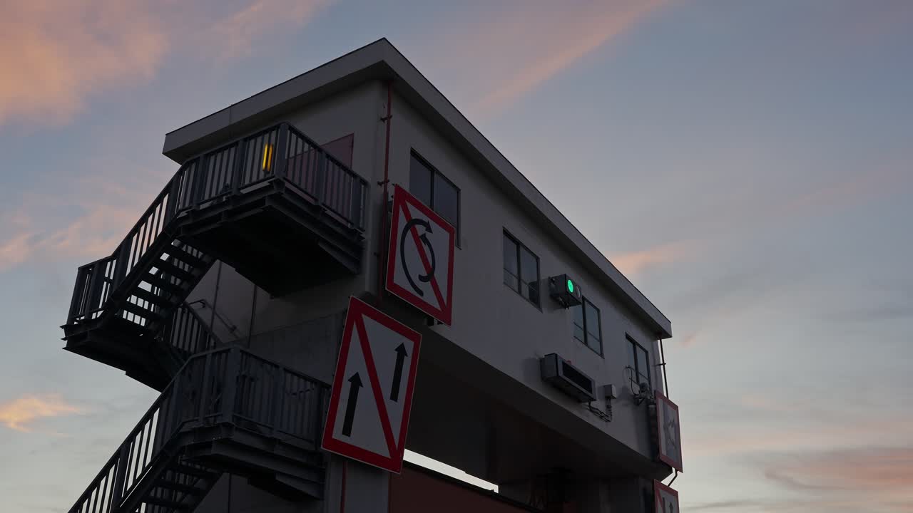 A low-angle shot of the Sumida Sluice Gate building against a beautiful, colorful evening sky