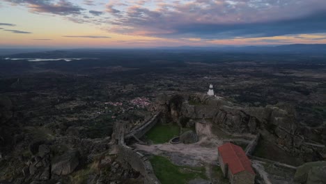 drone flying over monsanto castle at sunrise, portugal