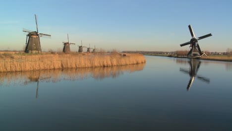 windmills line a canal in holland