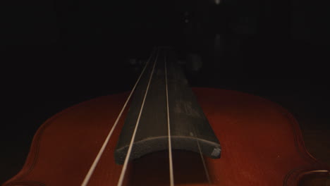 slider shot down the neck of a violin, as the headstock disappears into mysterious darkness.