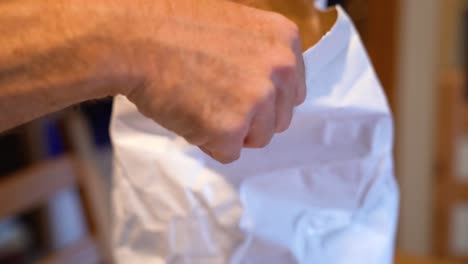 hands opening bag of freshly ground wheat flour