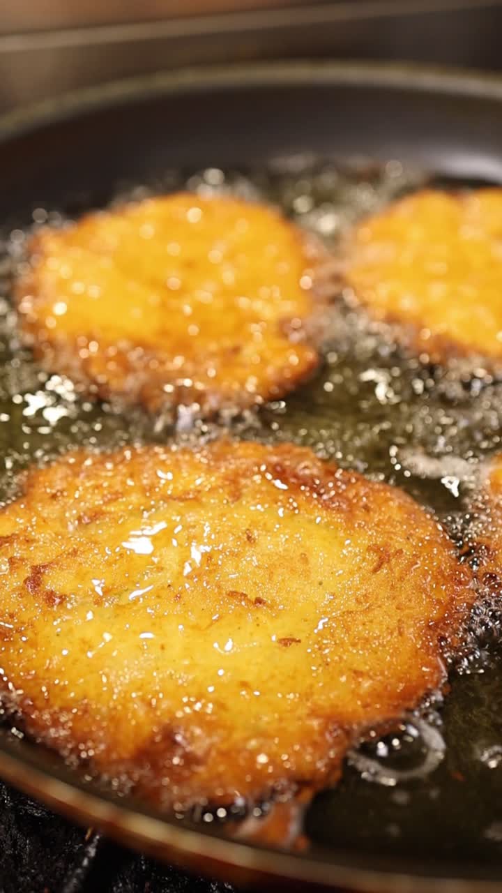 Frittelle dorate che friggono in olio caldo in una padella