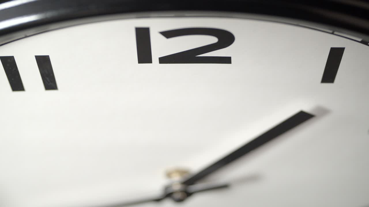 White Clock Face Close Up in Time Lapse on Dark Grey Wall
