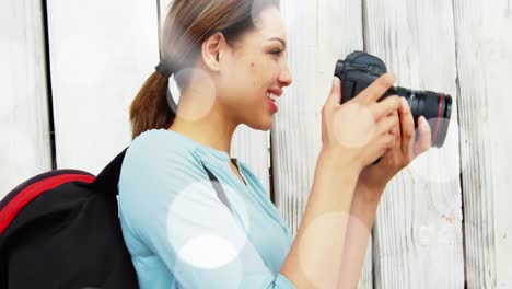 white spots floating against caucasian female photographer clicking pictures with digital camera