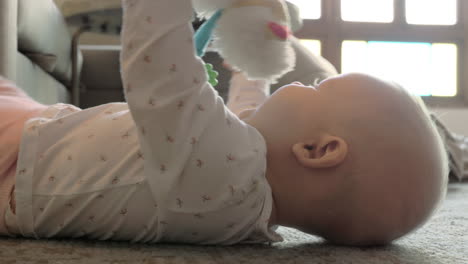 Active-baby-girl-playing-with-toy-on-the-floor