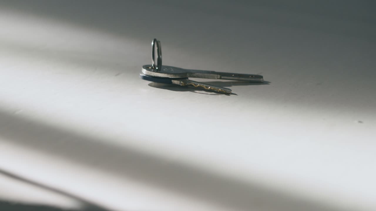 кто-то бросает ключи на белый стол, а кто-то другой ловит их.