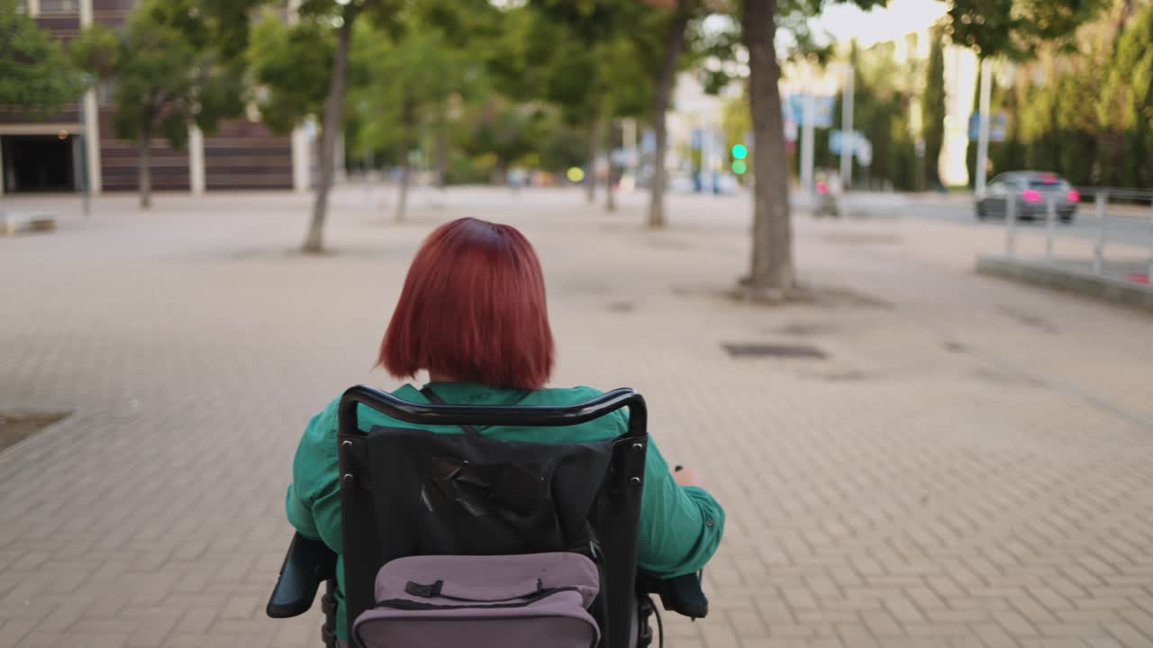 Person with Red Hair Moving in Electric Wheelchair in Urban Area