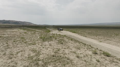 explorer jeep cruising through arid dirt steppe in vashlovani, georgia