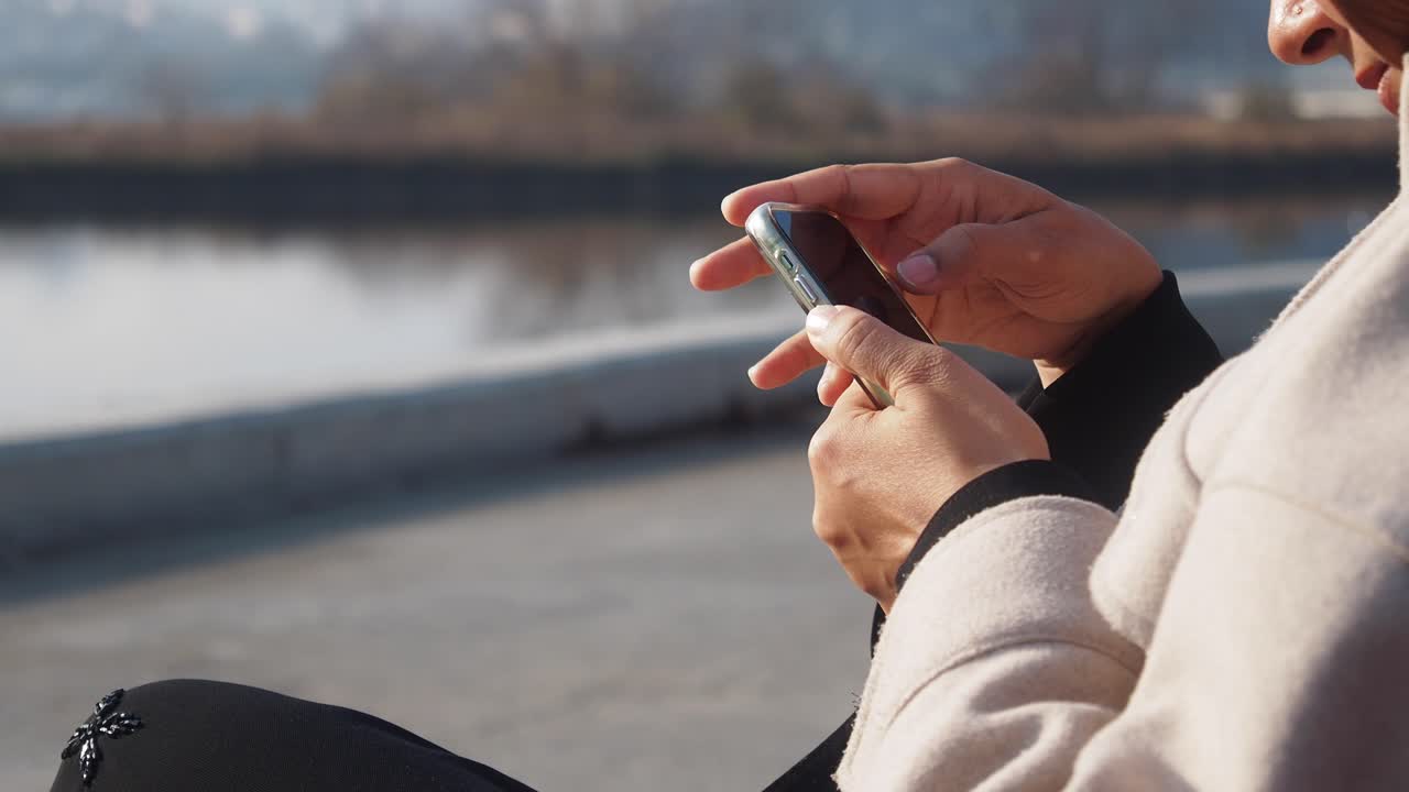Woman using smartphone outdoors by river