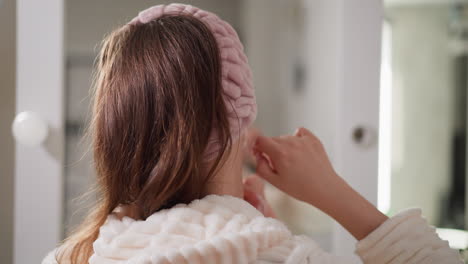 woman applying a face mask at home