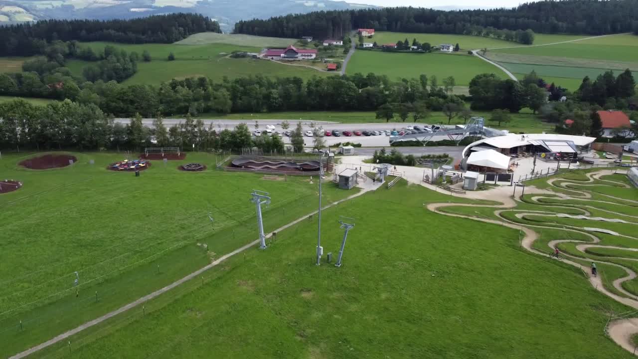 дронный снимок велосипедной тропы в парке - конечная точка долины с подъемником и тропой сверху - дрон быстро летит в сторону