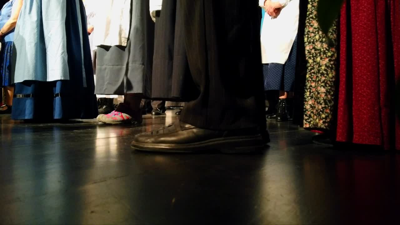 긴 전통 드레스를 입고 발을 두드리며 돌아다니는 사람들