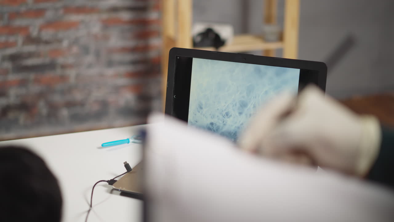 textura de la muestra bajo el microscopio mientras el empleado escribe