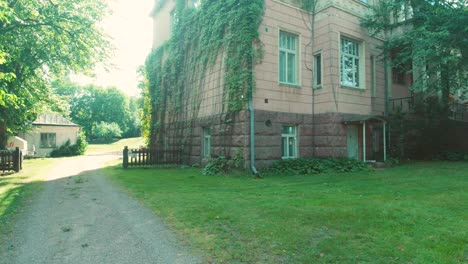 private property entrance with building facade and windows, garden and driveway next to side of house.
