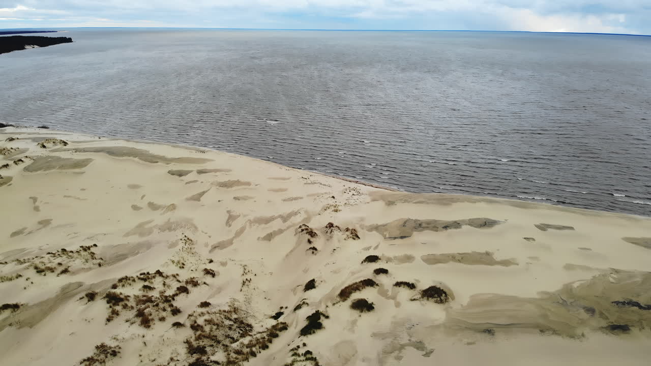 Aerial view of a coastline with sand dunes and the sea