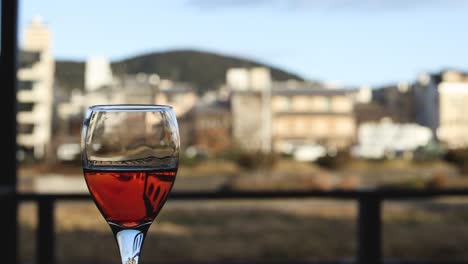vaso de vino con reflejo de la ciudad a lo largo del tiempo