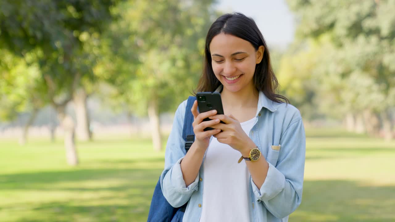 chica india feliz escribiendo en el teléfono