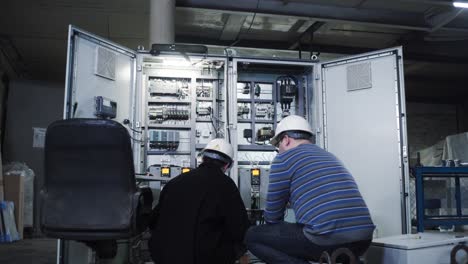 industrial technicians inspecting control panel