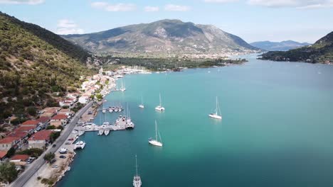 Nidri-Bay-and-Coastal-Road-at-Lefkada,-Greece---Reversing-Aerial