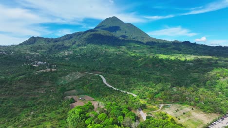 naturaleza exuberante con calle a aldea en frente de la montaña matutum en el paisaje tropical de filipinas