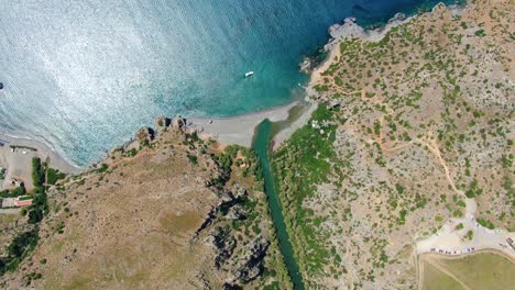 vista aérea de arriba hacia abajo de acantilados y olas rompiendo en la arena en creta, grecia, panoramización hacia el mar