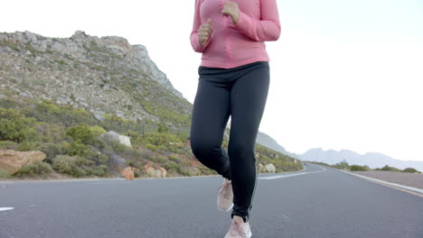 jogging on mountain road, woman in pink jacket enjoying outdoor exercise