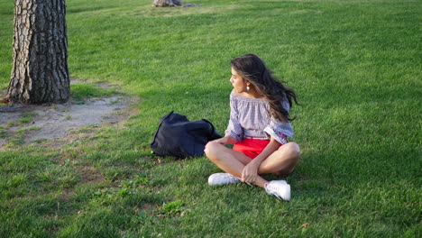 a beautiful young hispanic woman and her small pet dog playing together in a park field