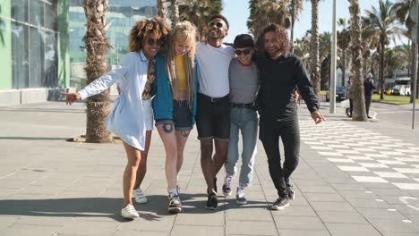 embracing happy friends walking on street