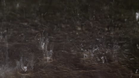 rain drops bouncing off of concrete sidewalk during a heavy rain shower