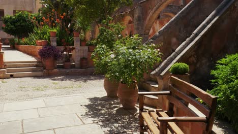 medieval mediterranean old town with picturesque green potted plants and flowers in greek orthodox monastery agia triada holy trinity, crete greece