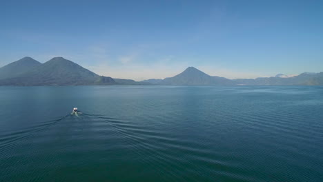 aerial over a boat on lake amatitlan in guatemala reveals the pacaya volcano in the distance 1