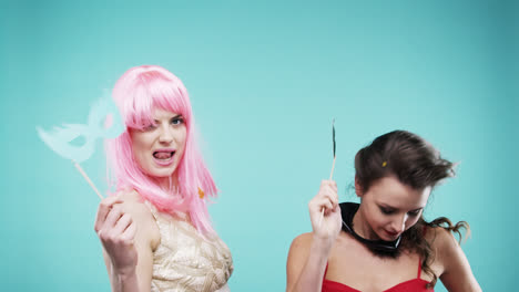 girlfriends dancing wearing red dress and pink hair in slow motion party photo booth