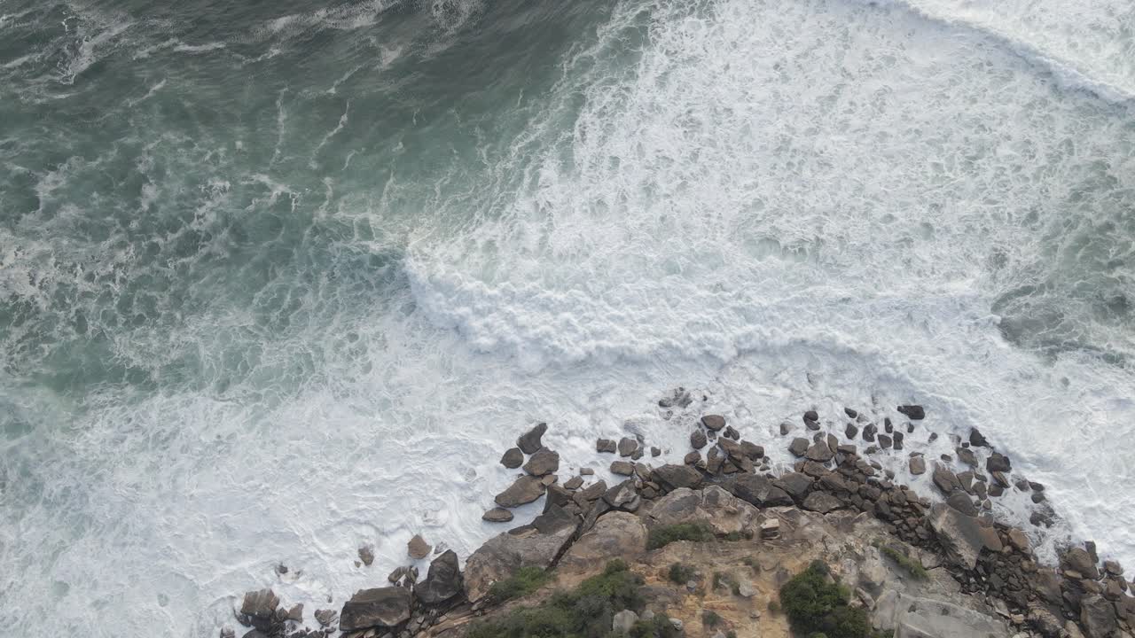 vista de arriba hacia abajo de olas blancas espumosas rompiendo en acantilados rocosos cerca de la bahía de gordons - suburbio del este, sydney, nsw, australia