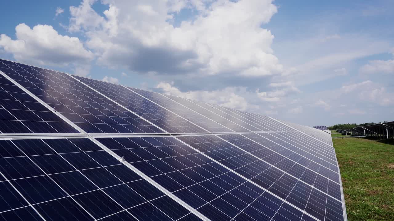 Close-up of modern photovoltaic solar battery panels. Rows of sustainable energy solar panels installed on field against the background of the sky with clouds