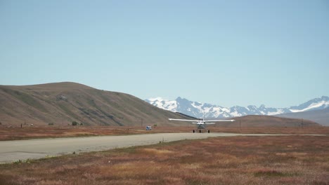 SLOWMO---Airplane-taking-off-with-snow-capped-rocky-mountains-in-background