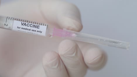 hypodermic injection with vaccine fluid placing needle, close up shot