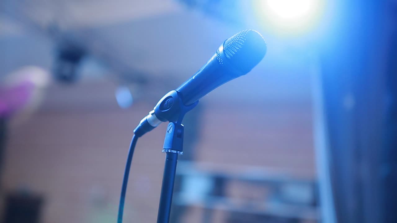 Microphone And Stage Lights. Close up of microphone in concert hall or conference room