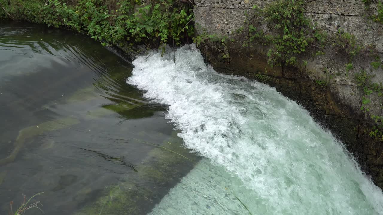 presa de río - flujo y salpicaduras de agua en el río frío.