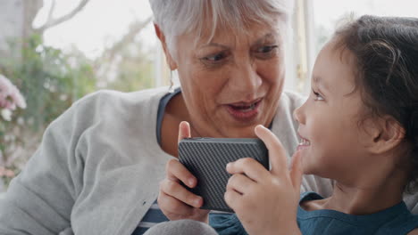 adorable-little-girl-showing-grandmother-how-to-use-smartphone-teaching-granny-modern-technology-intelligent-child-helping-grandma-with-mobile-phone-at-home-4k