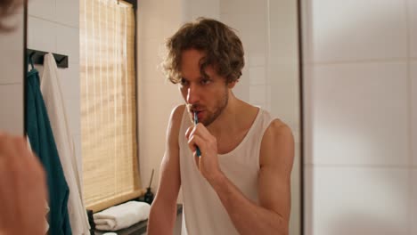 man brushing teeth in bathroom