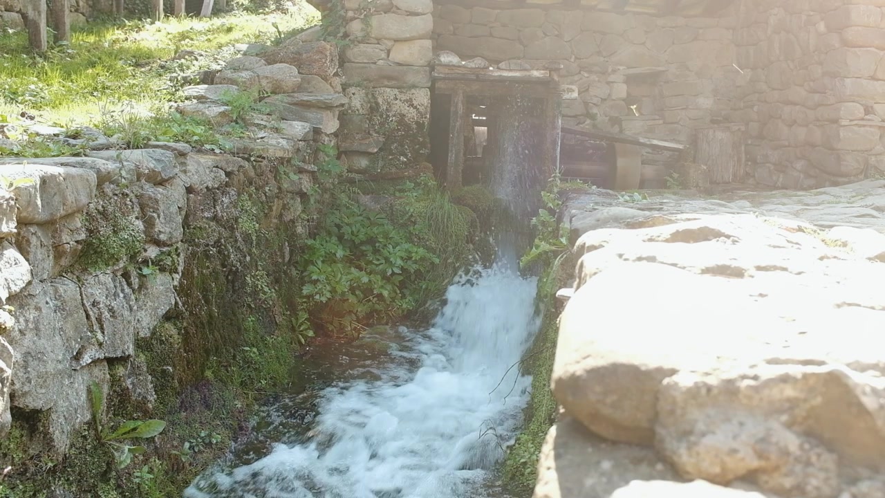 Gushing water from an old water driven mill. Using the power of water to turn machinery.