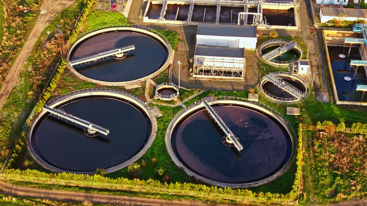 Efficient water treatment facility showcasing circular tanks in an industrial setting amidst green landscapes and clear skies