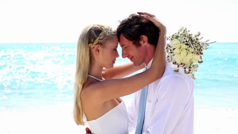 newlyweds embracing on the beach