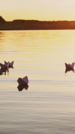 paper boats floating on a river. paper ships in water. vertical video