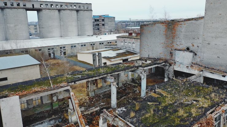 Vista aérea de um antigo edifício de fábrica em ruínas com detritos e tijolos quebrados com telhado desabado. Antigo edifício industrial para demolição