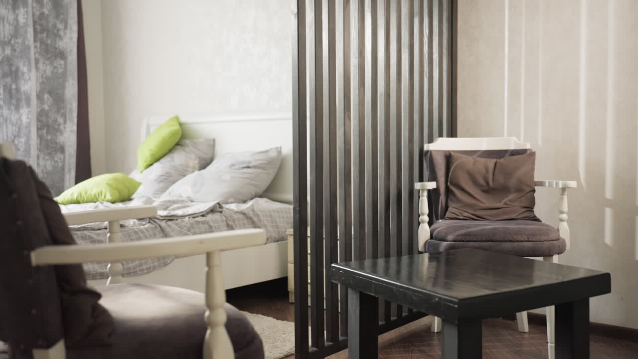 School girl in living room with room divider picks nail polish bottle from table near bed, long hair, striped pajamas, modern decor, pink remover visible, exits room carrying polish for manicure