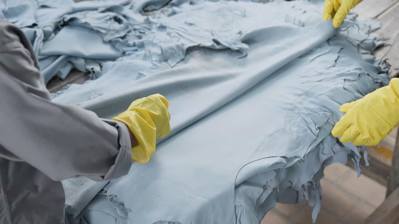 сотрудники кожевенной фабрики, измеряющие и маркирующие кожи животных во время производственного процесса