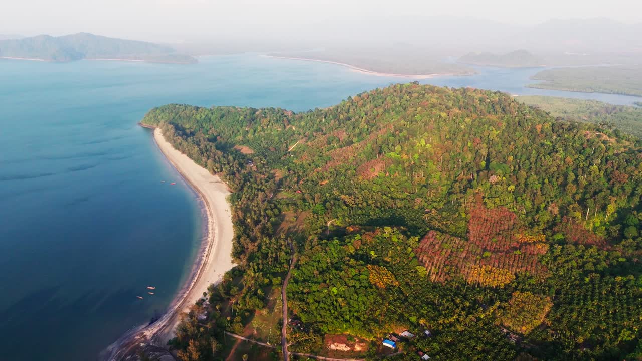 Lush green forest and blue ocean landscape at Laem Son National Park in Thailand, drone forward flyover.